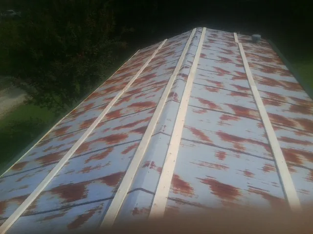 Rusted metal roof panels with new wood purlins before replacement — Storm Damage Roof Repair in Wise by Roofing Brothers