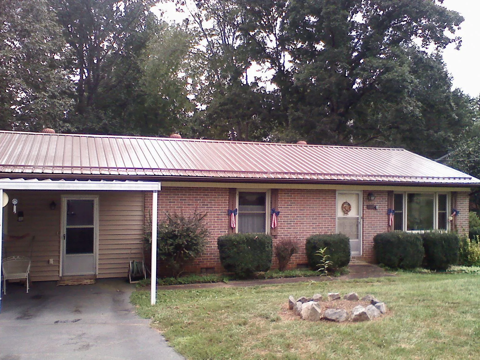 Bronze metal roof and carport on a brick ranch home — Roof Repair work by our crew in Wise